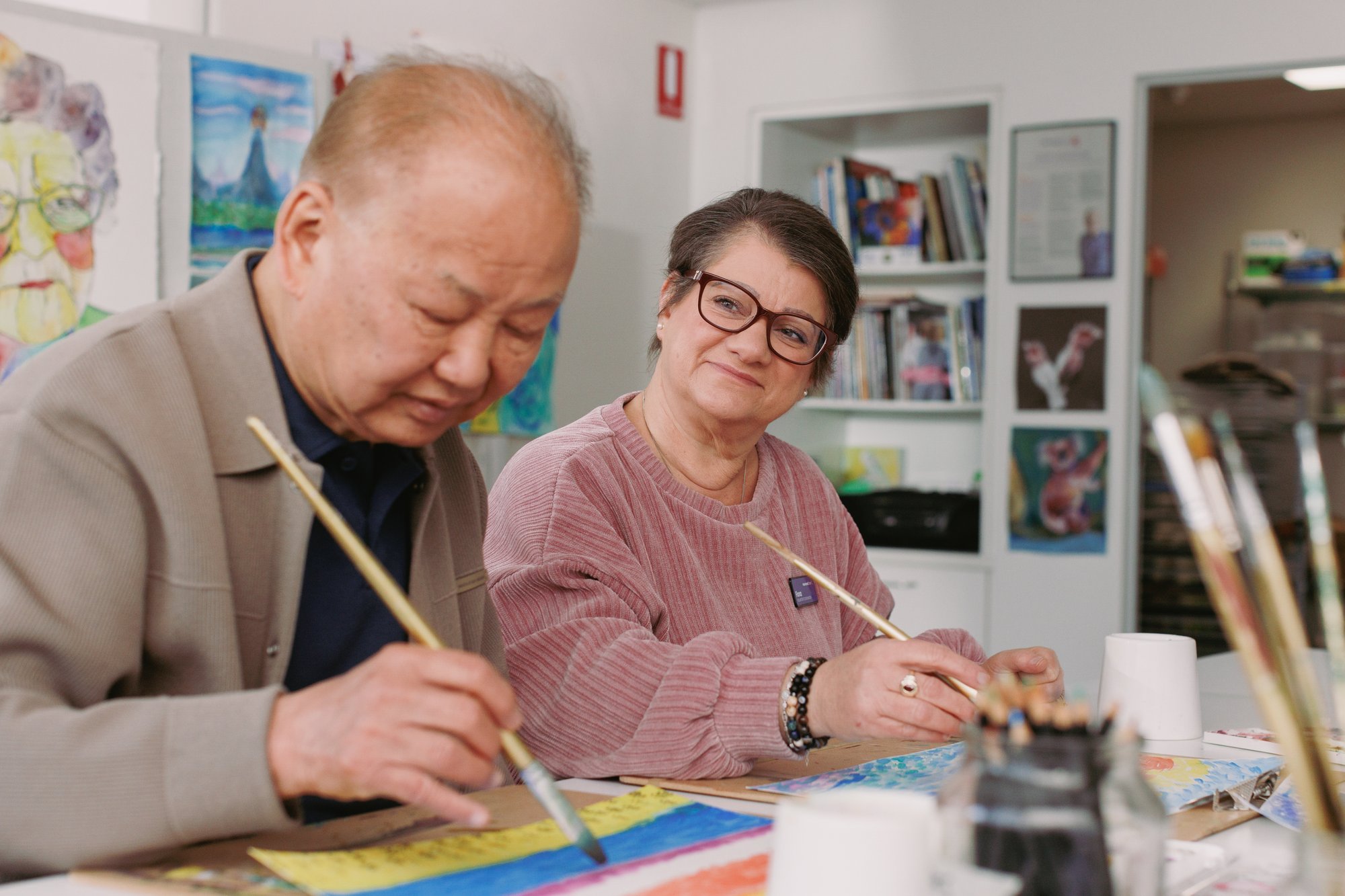 Image of resident painting with carer