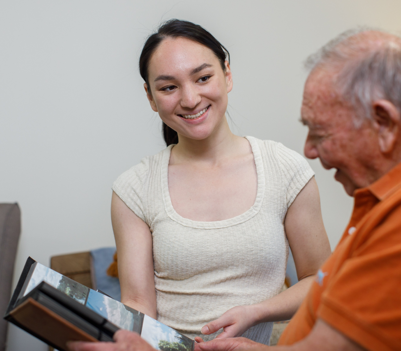 HammondCare worker looking at a photo book with a resident