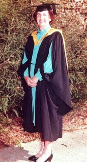 Pauline Potts poses in a graduation gown and cap