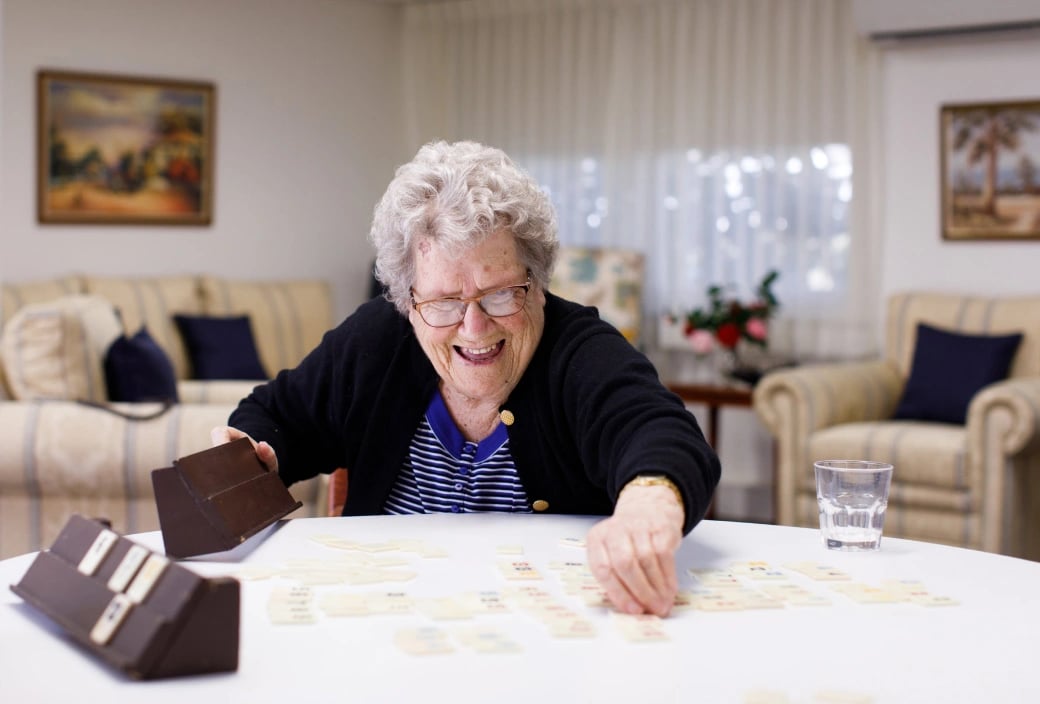 A woman enjoys a game with friends at a HammondCare respite cottage