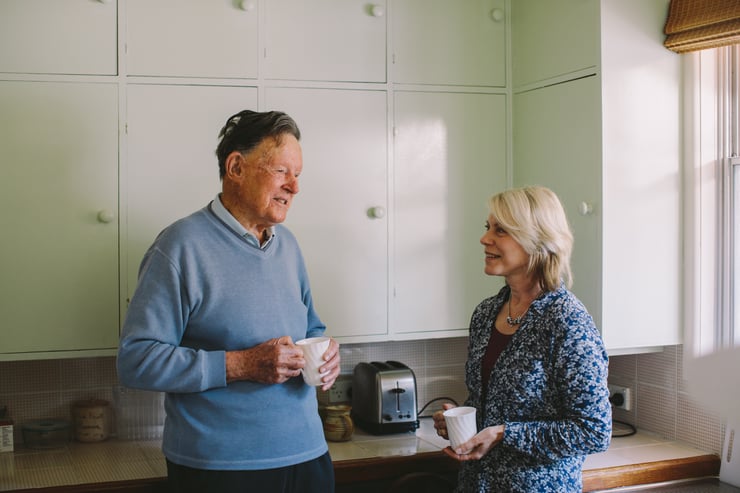 John stands in the kitchen sharing a cup of tea and a chat with his Hammondcare At Home carer